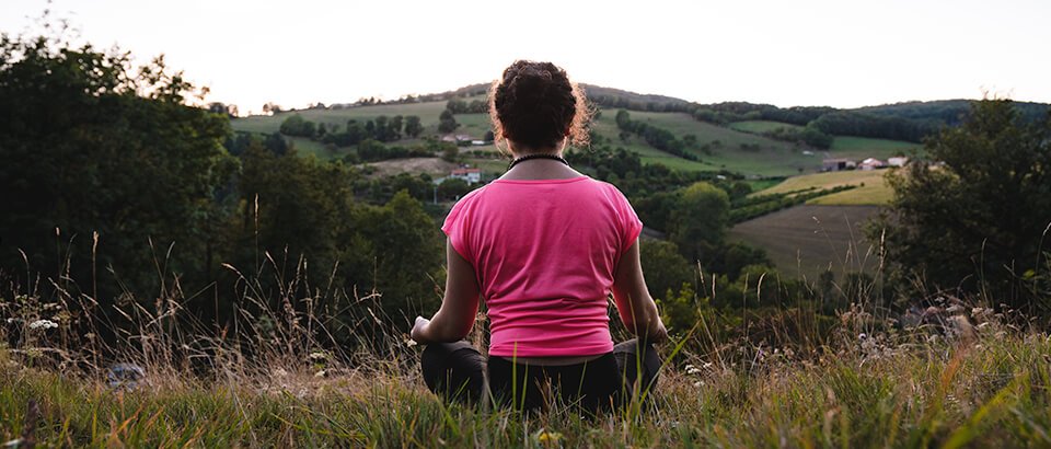 Woman sitting outside in meditation