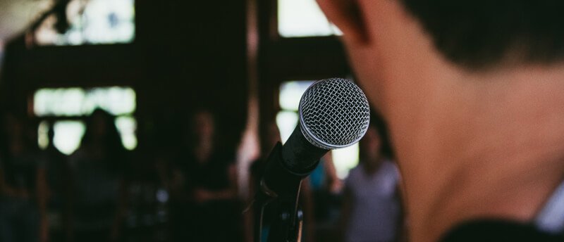 a close up of a microphone with a person in the background.
